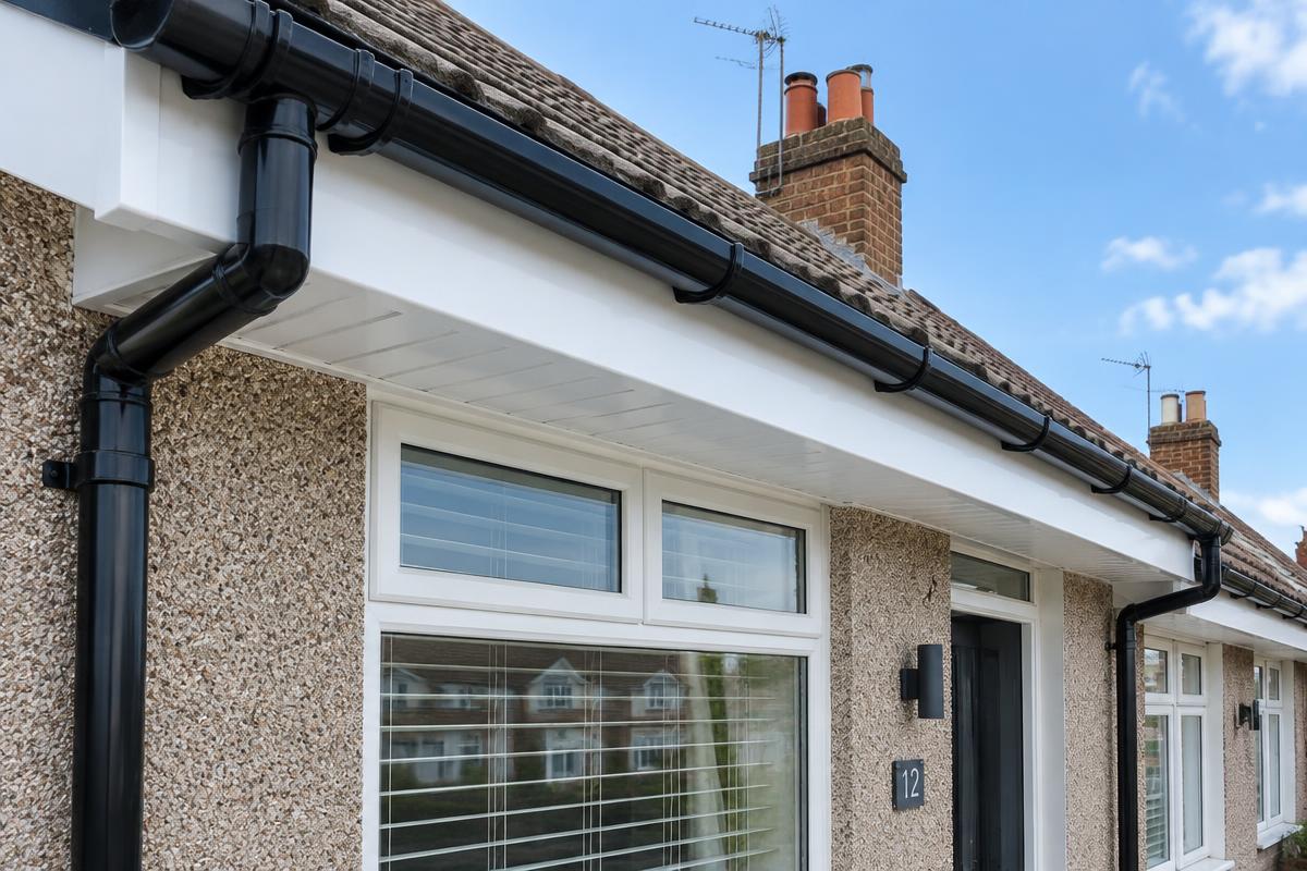 New white fascia, soffit and black guttering on a roofline